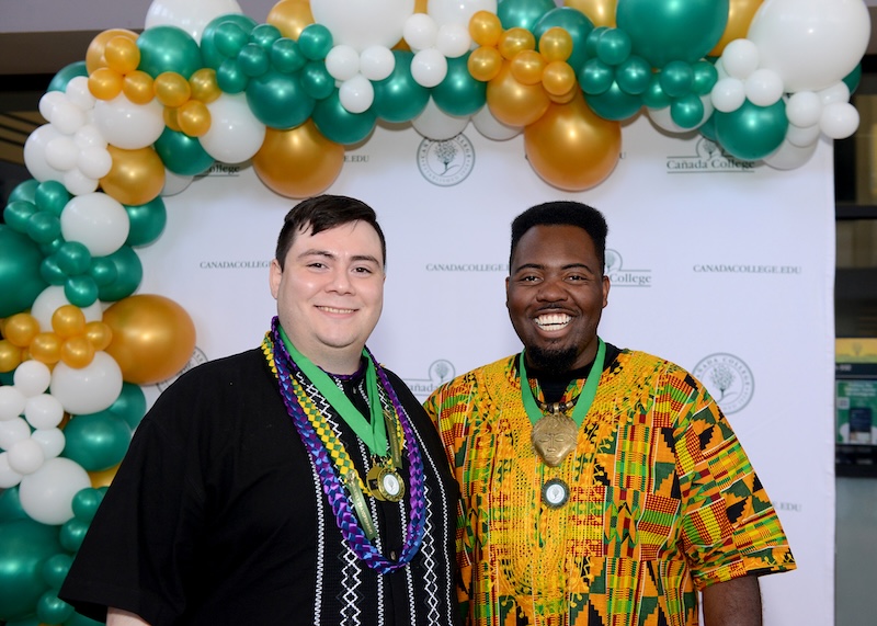 Two students proudly posing with medals awarded for scholarships at the Student Recognition and Achievement Ceremony.